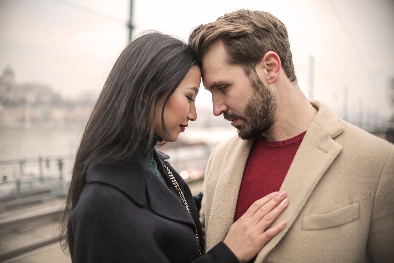 A loving couple sharing a tender moment outdoors on a winter day.